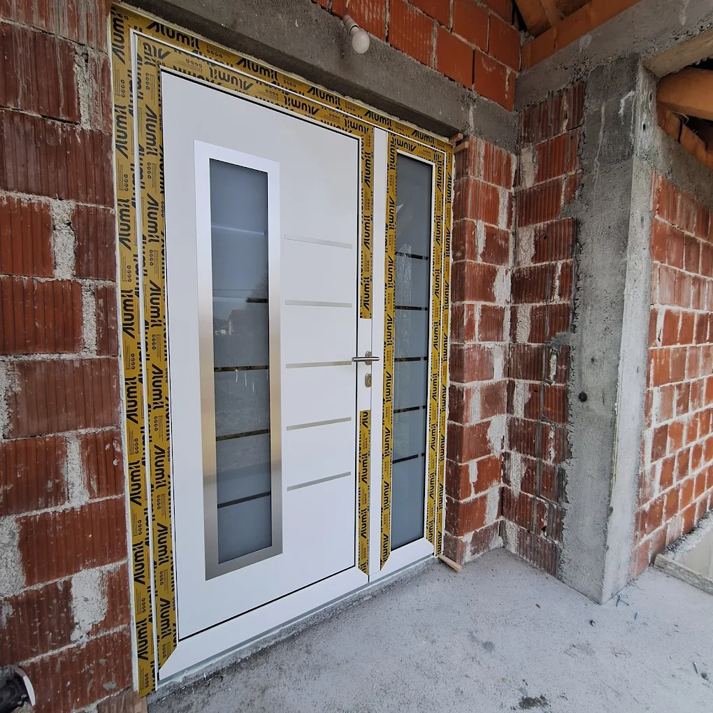 Bela aluminijumska vrata sa ugrađenim staklenim panelima